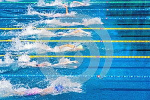 Young swimmers in outdoor swimming pool during competition. Health and fitness lifestyle concept with kids.