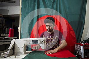 A young tailor Md. Rashed Alam , Age 28 making Bangladeshi national flags at Dhaka, Bangladesh.