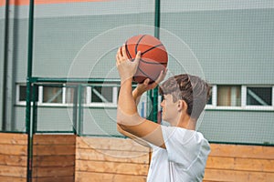 Young talented basketball player is shooting hoops on his outdoor court and training for future games and tough situations.