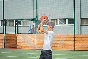 Young talented basketball player is shooting hoops on his outdoor court and training for future games and tough situations.