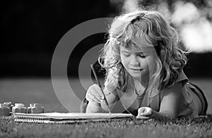 Young talented boy artist painter. Portrait of smiling happy kid enjoying art and craft drawing in backyard or spring
