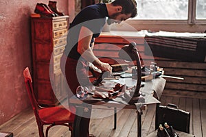 Young talented shoemaker brushing the shoes