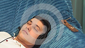 Young tanned man close-up in a white t-shirt at home listening to relaxing music. relaxation relaxation, calmness