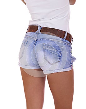 Young tanned woman wearing blue short jean on white background