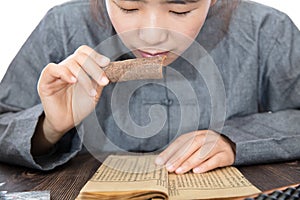 Young TCM pharmacists read books to study the properties of cinnamon