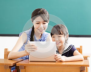 Young Teacher helping child with computer lesson