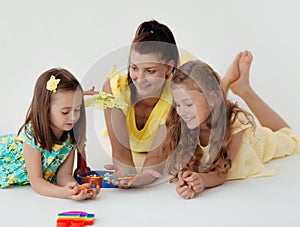 Young teacher and preschool children learn the English alphabet using cards, blocks and toys