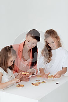 Young teacher and preschool children learn the English alphabet using cards, blocks and toys