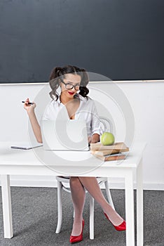 young teacher sitting at workdesk