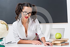 young teacher sitting at workdesk in front