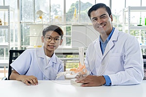 Young teacher and student boy learning anatomy of the human foot