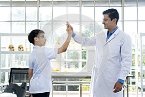 Young teacher and student boy in science class at laboratory
