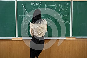 young teacher or student standing near blackboard and learn math lesson