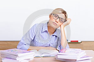 Young teacher surrounded with assignments