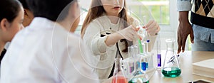 Young teacher teaching group student about science and test chemical for liquid in the lab of school.