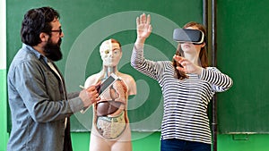 Young teacher using Virtual Reality Glasses and 3D presentation. Education, VR, Tutoring, New Technologies and Teaching Methods.