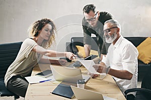 Young team of coworkers making great work discussion in modern office.Bearded man talking with marketing director and photo