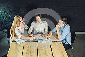 Young team of coworkers watching storyboard for shooting video in modern coworking office. Teamwork process. Horizontal