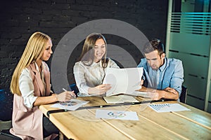 Young team of coworkers watching storyboard for shooting video in modern coworking office. Teamwork process. Horizontal,blurred ba