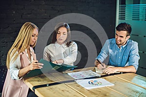 Young team of coworkers watching storyboard for shooting video in modern coworking office. Teamwork process. Horizontal,blurred ba