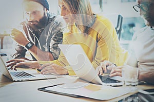 Young team of coworkers working together in modern coworking office.Bearded man talking with colleague about new startup