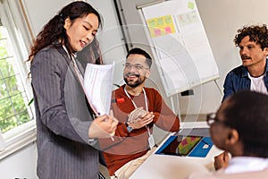 Young team leader giving a presentation to a group of young colleagues