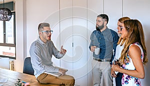 Young team leader in an informal meeting explaining project