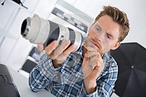 Young technician cleaning camera lense