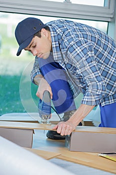 Young technician installing floor at construction site