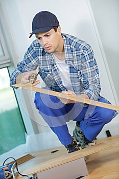 Young technician installing floor at construction site