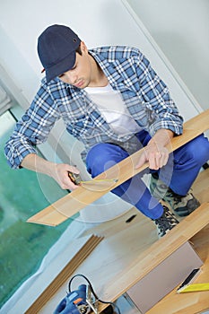 young technician installing floor at construction site