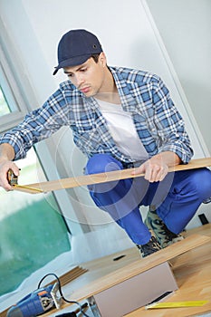 Young technician installing floor at construction site