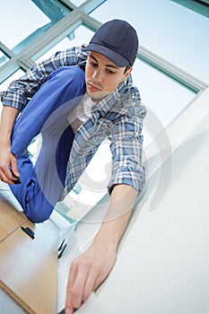 Young technician installing floor at construction site