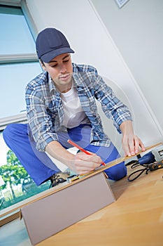 Young technician installing floor at construction site