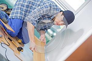 Young technician installing floor at construction site