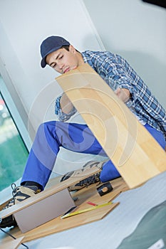 young technician installing floor at construction site