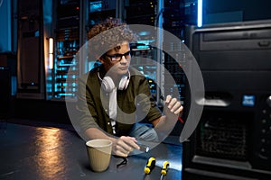 Young IT technician repairing computer in modern data center
