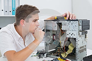 Young technician working on broken computer