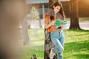 A young or teen asian girl student in university smiling and reading the boo