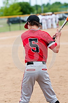 Young teen baseball player from behind