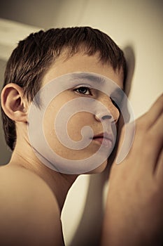 Young Teen Boy with Ear Pressed to Wall