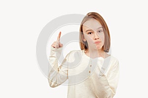 Young teen boy with long hair posing at studio. Guy pointing up at empty space. Boy gesturing new idea