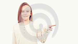 Young teen boy with long hair posing at studio. Guy showing aside at empty space