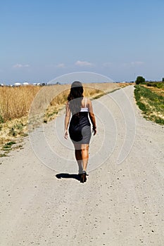 Young Teen Caucasian Girl Walking Down Gravel Road In Dress