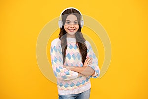 Young teen child listening music with headphones. Girl listening songs via wireless headphones. Wireless headset device