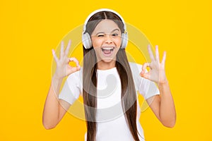 Young teen child listening music with headphones. Girl listening songs via wireless headphones. Wireless headset device