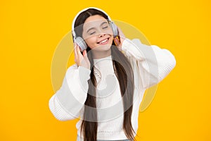 Young teen child listening music with headphones. Girl listening songs via wireless headphones. Wireless headset device