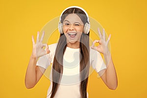 Young teen child listening music with headphones. Girl listening songs via wireless headphones. Wireless headset device