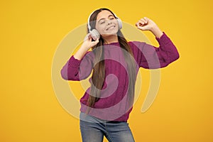 Young teen child listening music with headphones. Girl listening songs via wireless headphones. Wireless headset device