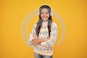 Young teen child listening music with headphones. Girl listening songs via wireless headphones. Wireless headset device